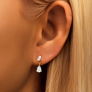 Close-up of gold-plated silver earrings with marquise and teardrop-shaped clear crystals
