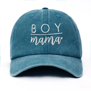 Close-up of BOY mama white embroidery on washed blue cotton vintage baseball cap