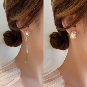 Detail showing long tassel drop earrings with white pearls and sparkling crystals