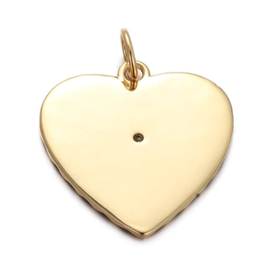 Macro view of a gold-plated heart pendant with smooth metallic texture and bail
