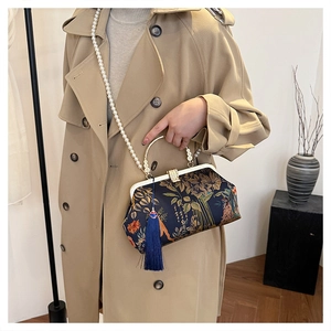 Close-up of vintage dark blue floral brocade bag with pearl chain and silk tassel