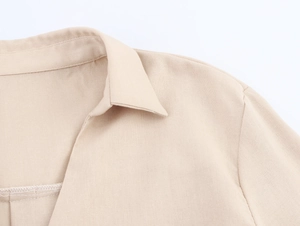 Detailed close-up of light beige cotton linen shirt collar with neat stitching work