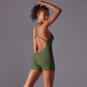 Close-up of ruched peach lift detail and backless cutout on green yoga jumpsuit