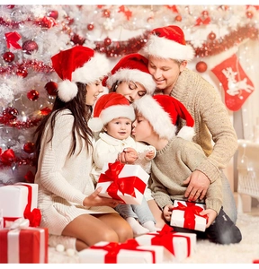 Family wearing thick plush Santa hats in a cozy holiday home setting with gifts