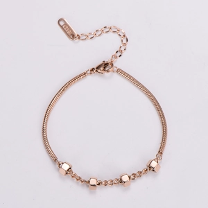 Detail of rose gold snake chain bracelet featuring hexagon nut beads and 18KGP engraving