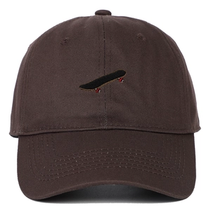 Detail view of coffee brown baseball cap featuring small embroidered skateboard pattern