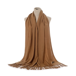 Detail of caramel knit cashmere scarf showing soft texture and elegant fringe tassels