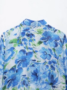 Detail shot of blue floral print and lightweight fabric texture on back of woman's shirt