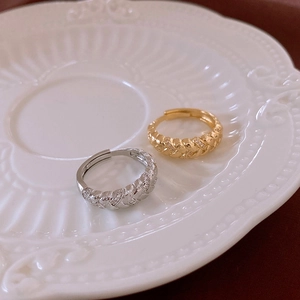 Detail of vintage woven twist rings with zircon accents in gold and silver finish