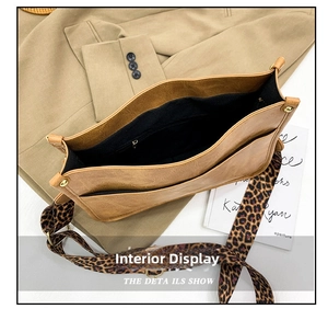 Detail view of the brown leather bag interior featuring leopard strap and zipper pockets