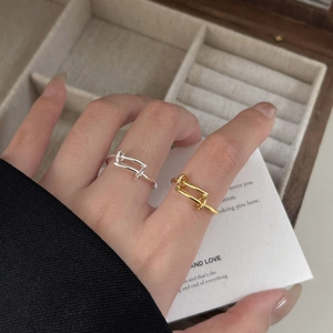 Detailed shot of minimalist 925 sterling silver rectangular rings in gold and silver