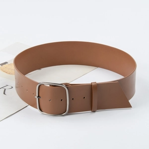 Classic brown leather wide belt with silver square pin buckle on a fashion magazine