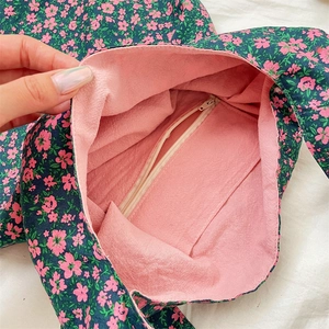 Detail view of the floral canvas bag showing the pink lining and interior zipper pocket