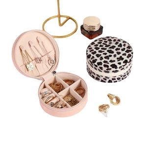 Portable round jewelry box with leopard print and pink interior featuring a mirror