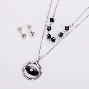 Dettaglio di set collana e orecchini in acciaio argentato con ciondoli a forma di occhio