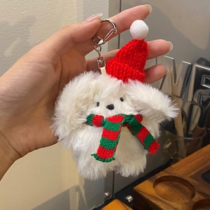 Close-up of white plush bunny keychain with red Christmas hat and striped scarf