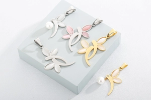 Macro view of leaf pendants with opal-style stones and pearls in gold and silver