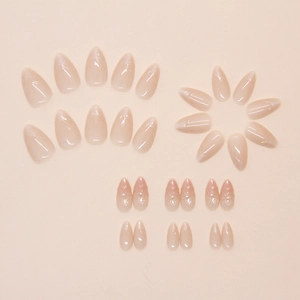 Détail de faux ongles amande courts avec accents de perles et effet dégradé œil de chat