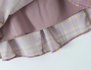 Close-up of purple lining and yellow checkered fabric details on a ruffled mini skirt