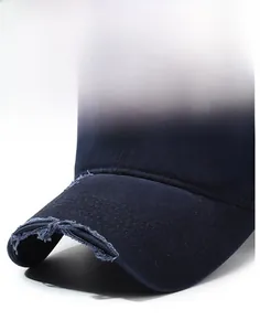 Close-up of distressed brim on washed navy blue baseball cap with torn vintage details