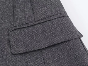 Dettaglio ravvicinato del tessuto grigio scuro e della cucitura sulla tasca del blazer