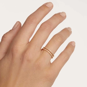 Close-up of a double-layered gold eternity ring with pavé diamonds on a model's hand