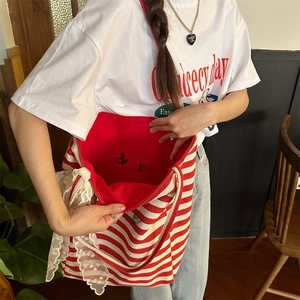 Detail of red striped canvas tote bag showing lace trim and red butterfly lining