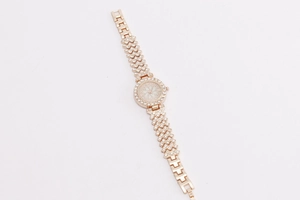 Macro detail of rose gold floral quartz watch with rhinestone-encrusted link strap