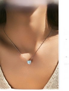 Nahaufnahme der S925 Silberkette mit herzförmigem Opal-Anhänger am Hals der Frau