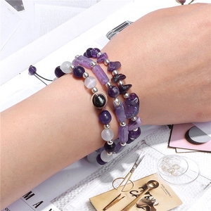 Detail of layered natural purple agate and amethyst beaded bracelets set on model wrist