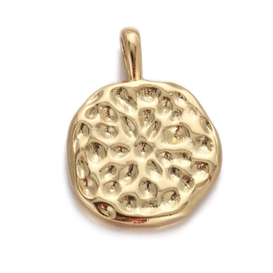 Close-up of golden round pendant with hammered texture and small bail on white background