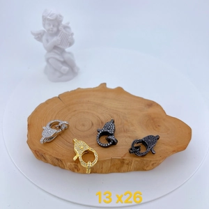 Micro-set zircon lobster clasps in gold and silver finish on a wooden base