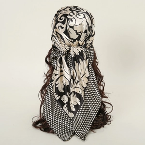 Detail of floral and polka dot silk-like scarf tied on a model's head from behind