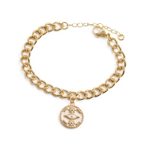 Chunky gold chain bracelet with zircon evil eye pendant in a polished metallic finish