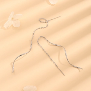 Detail showing elegant silver stainless steel wavy tassel threader earrings in a macro view