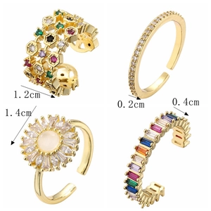 Macro shot of four adjustable gold flower rings with colorful zircon and opal stones