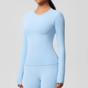Détail du tissu brossé extensible et de la coupe ajustée sur le haut de yoga bleu clair