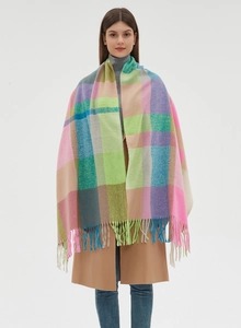 Close-up of a colorful plaid scarf featuring soft pink and green hues with long fringe details