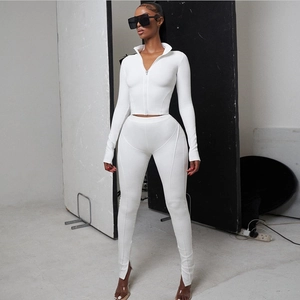 Detailed view of white slim fit yoga set with zip-up jacket and slit hem leggings