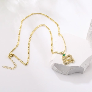 18K gold plated snake pendant necklace with green crystals on white rock background