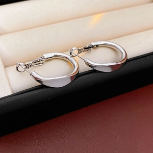 Macro view of silver hoop earrings with polished smooth finish and clasp structure