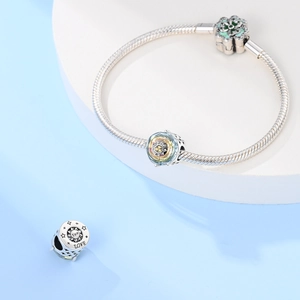 Dettaglio macro del bracciale a maglia serpente argento con ciondoli Sun e Love