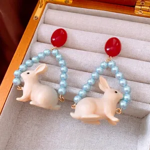 Cute bunny dangle earrings with red beads and pearls for women in a jewelry box