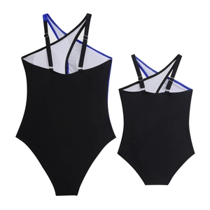 Flat lay of matching black and royal blue one-piece family swimwear for mother and child