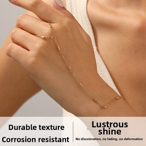 Detailed view of a gold-plated stainless steel hand chain with round tube charms on a hand
