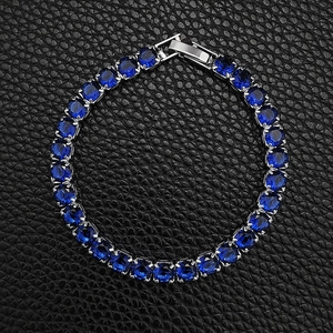 Macro view of blue zircon tennis bracelet with silver prong setting and fold-over clasp