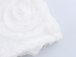 Détail rapproché d'une rose en tulle blanc ornant cette robe élégante de style français