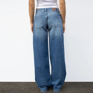 Vue arrière du jean large bleu délavé vintage montrant la taille haute et la texture denim