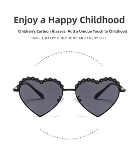 Detail of heart-shaped kids sunglasses with black floral trim and dark polarized lenses