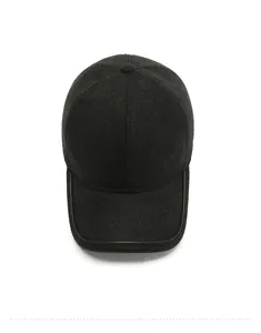 Top view of wool baseball cap showing premium metal mountain emblem and leather brim edge